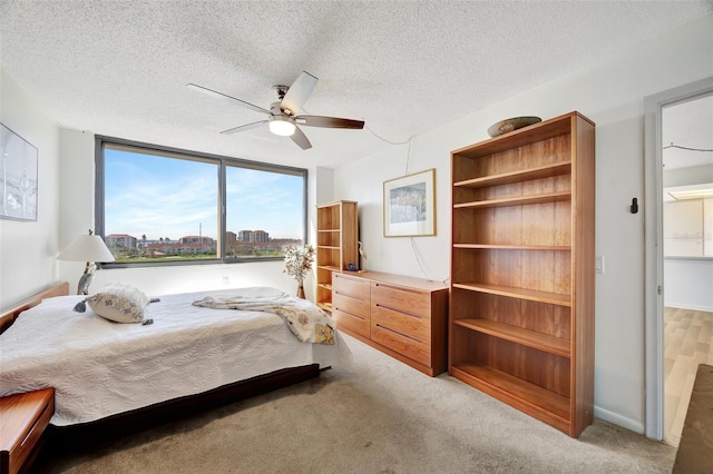 carpeted bedroom featuring a textured ceiling and ceiling fan