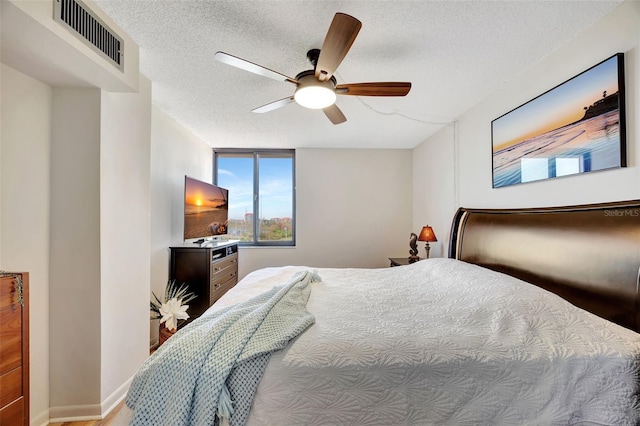 bedroom with ceiling fan and a textured ceiling