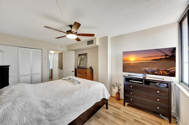 bedroom with ceiling fan, a closet, a textured ceiling, and light hardwood / wood-style flooring