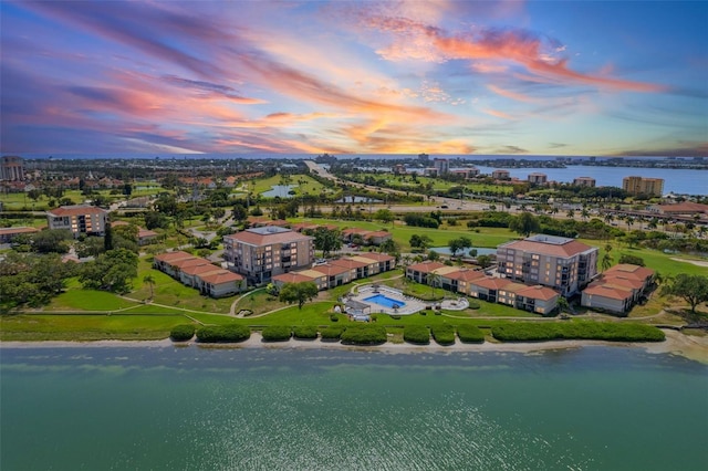 aerial view at dusk featuring a water view