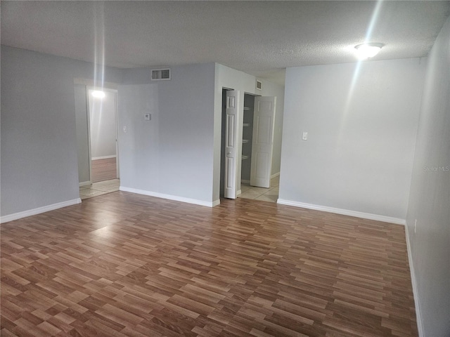 spare room with hardwood / wood-style flooring and a textured ceiling