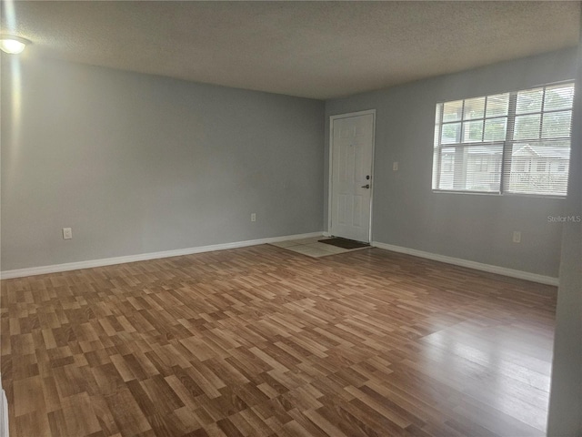 spare room with a textured ceiling and hardwood / wood-style flooring