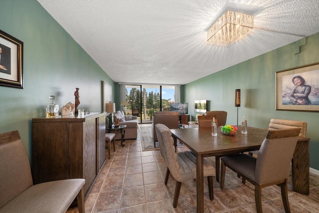 tiled dining area featuring expansive windows, a chandelier, and a textured ceiling