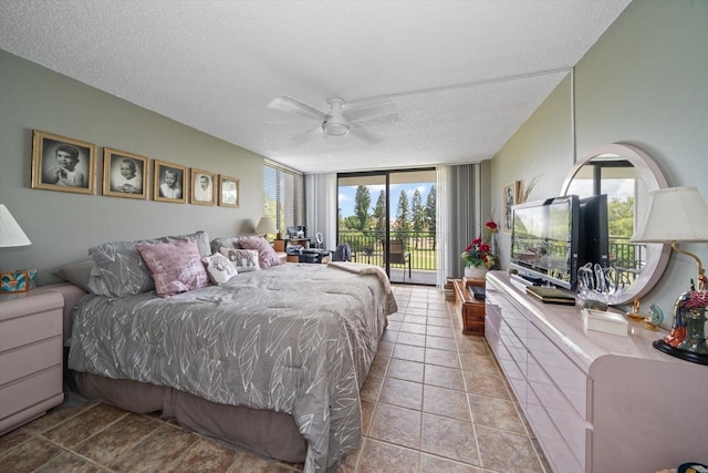 bedroom featuring expansive windows, light tile patterned floors, a textured ceiling, and access to outside