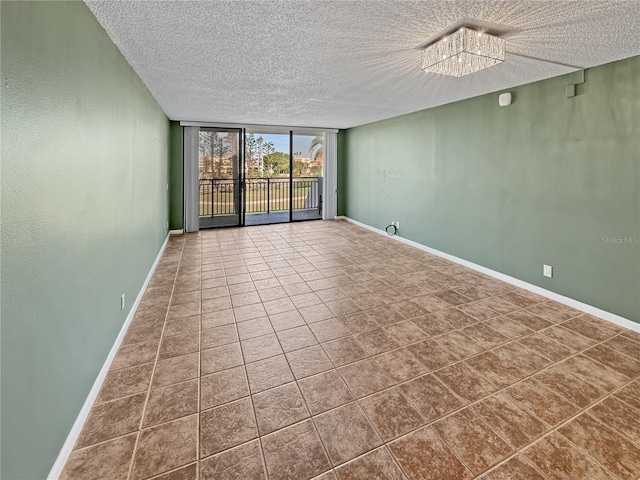 tiled spare room with expansive windows and a textured ceiling