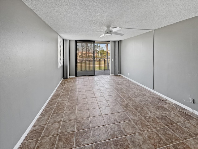 tiled empty room with ceiling fan, floor to ceiling windows, and a textured ceiling