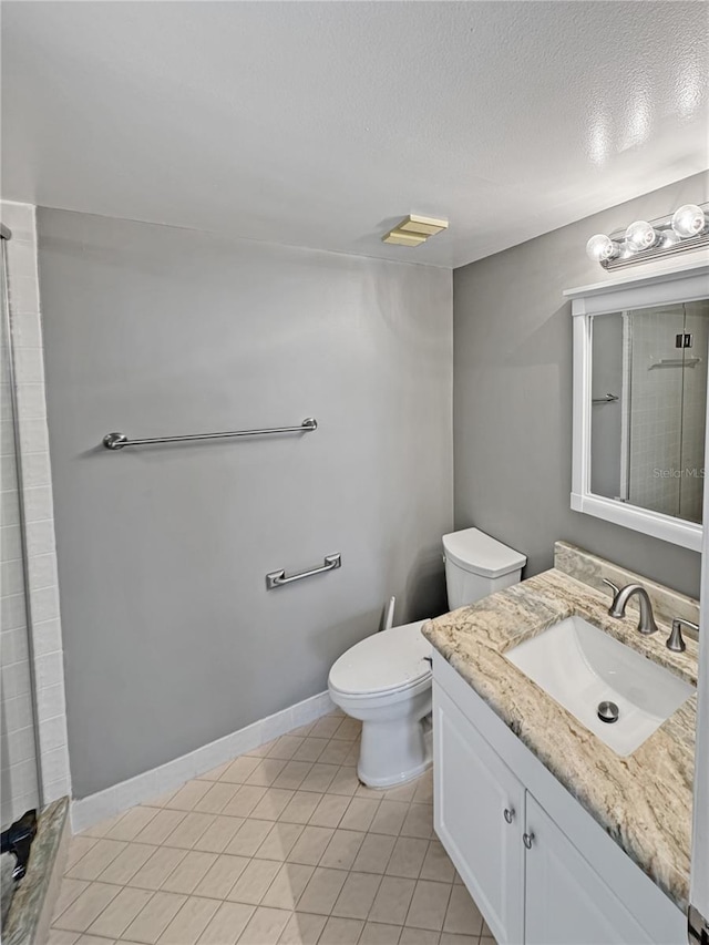 bathroom featuring vanity, a shower with shower door, tile patterned floors, and toilet