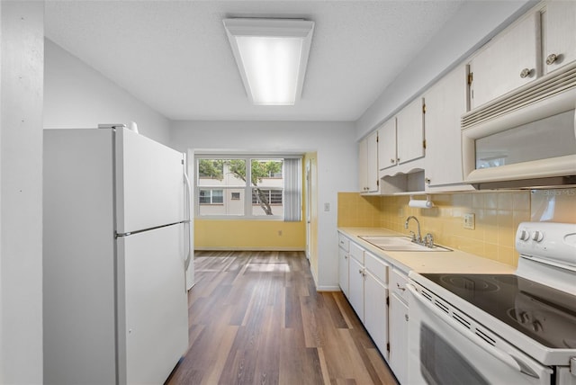 kitchen with decorative backsplash, white appliances, white cabinetry, and sink