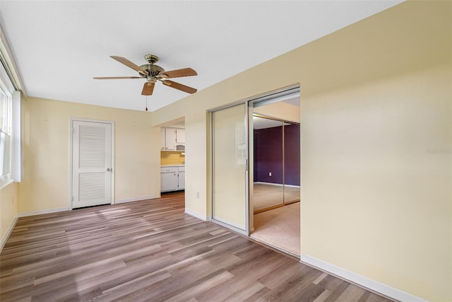 unfurnished bedroom featuring light wood-type flooring and ceiling fan