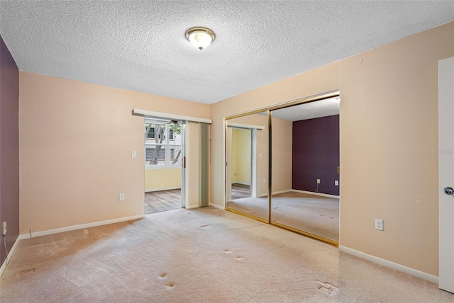 unfurnished bedroom with carpet flooring, a textured ceiling, and a closet