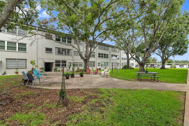 view of community with a lawn and a patio area