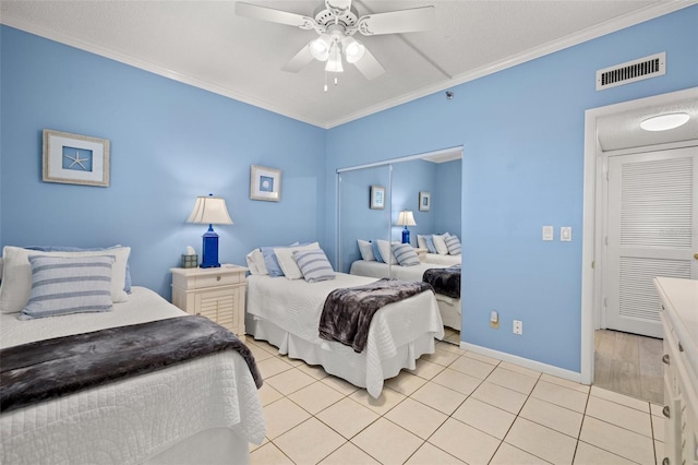 tiled bedroom with ceiling fan, a textured ceiling, and ornamental molding