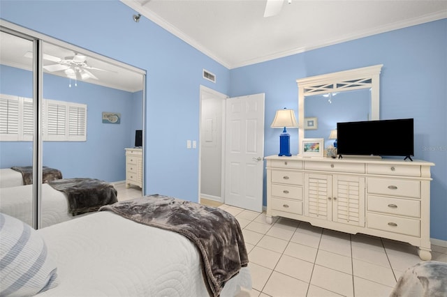 bedroom with ceiling fan, a closet, light tile patterned flooring, and crown molding