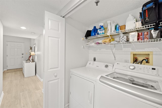 clothes washing area featuring a textured ceiling, independent washer and dryer, and light hardwood / wood-style floors