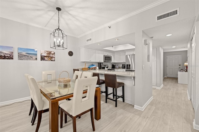 dining area with light hardwood / wood-style floors, a textured ceiling, crown molding, and a chandelier