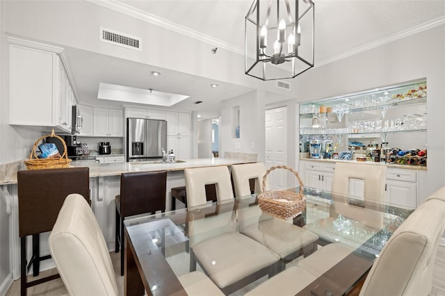 dining room featuring crown molding, an inviting chandelier, and sink