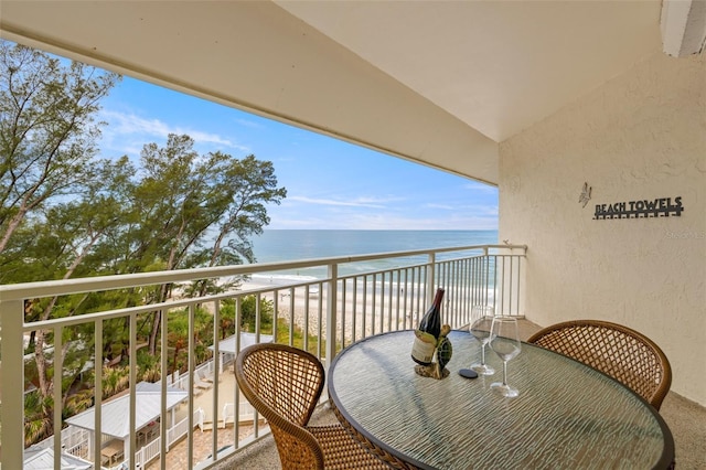 balcony featuring a water view and a beach view