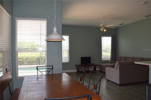 dining room with dark tile patterned flooring, ceiling fan, and a wealth of natural light