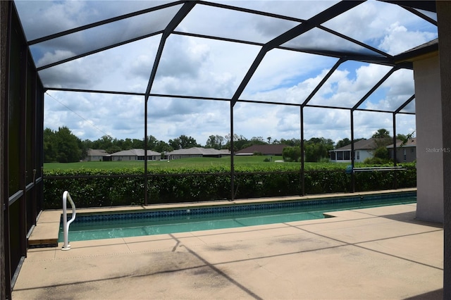 view of swimming pool featuring glass enclosure and a patio area