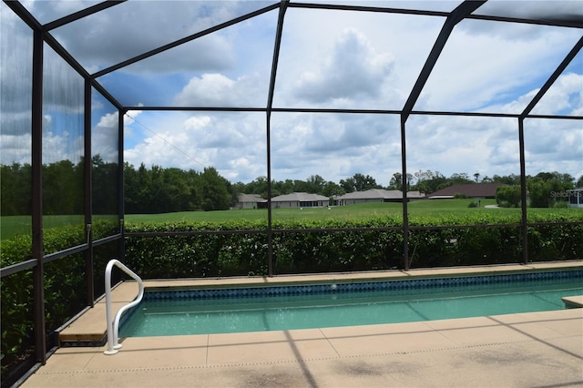 view of pool with glass enclosure and a patio area