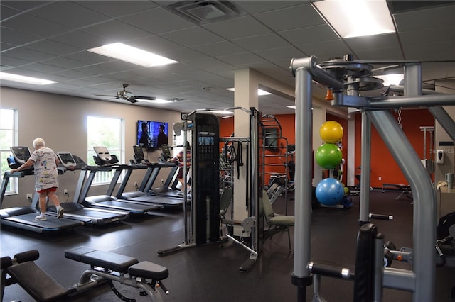 exercise room with a paneled ceiling and ceiling fan