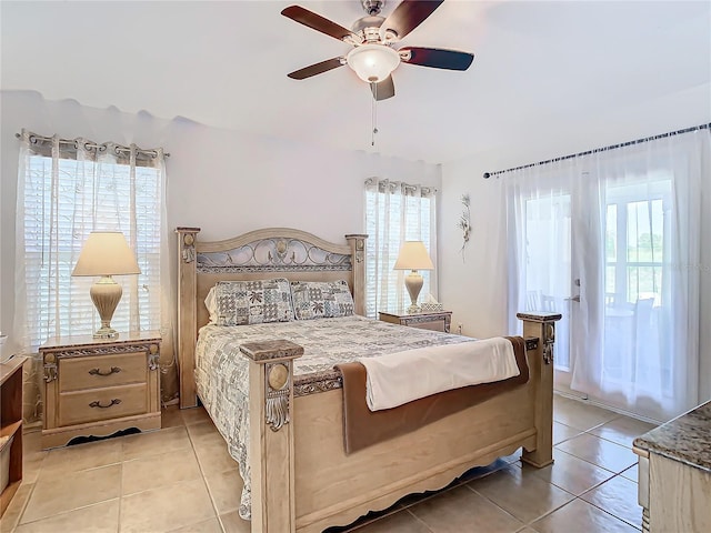 bedroom with ceiling fan, light tile patterned floors, and multiple windows