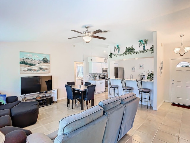 11247 Corey Pavin Ln, San Antonio, FL 33576 - living area featuring light tile patterned floors, baseboards, visible vents, lofted ceiling, and ceiling fan with notable chandelier