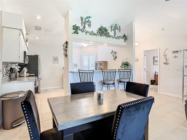 11247 Corey Pavin Ln, San Antonio, FL 33576 - dining room featuring light tile patterned floors, a high ceiling, and visible vents