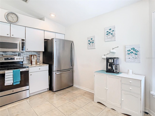 11247 Corey Pavin Ln, San Antonio, FL 33576 - kitchen with stainless steel appliances, lofted ceiling, tasteful backsplash, light countertops, and white cabinets