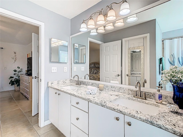 11247 Corey Pavin Ln, San Antonio, FL 33576 - bathroom featuring double vanity, baseboards, a sink, and tile patterned floors