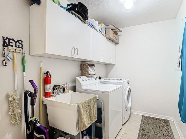 11247 Corey Pavin Ln, San Antonio, FL 33576 - laundry area with washing machine and clothes dryer, light tile patterned floors, cabinet space, a sink, and baseboards