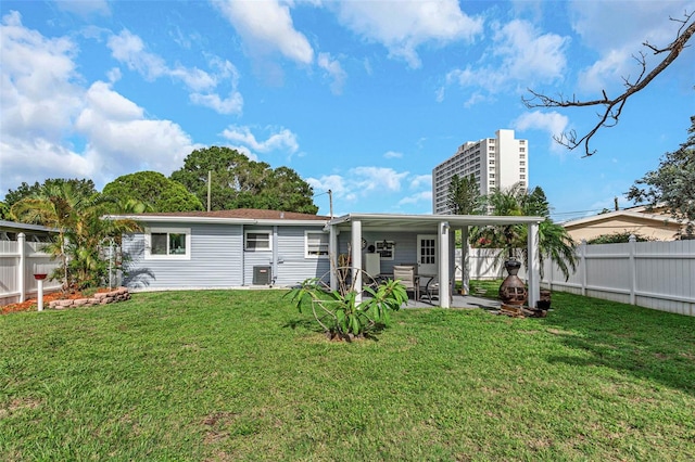 rear view of house with a patio, central AC unit, and a lawn