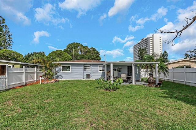 rear view of property with a lawn and a patio