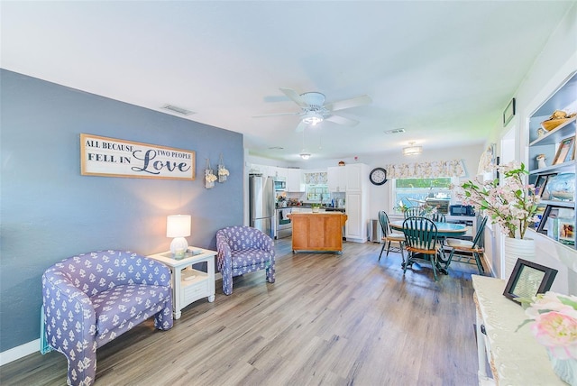 living room featuring light hardwood / wood-style flooring and ceiling fan