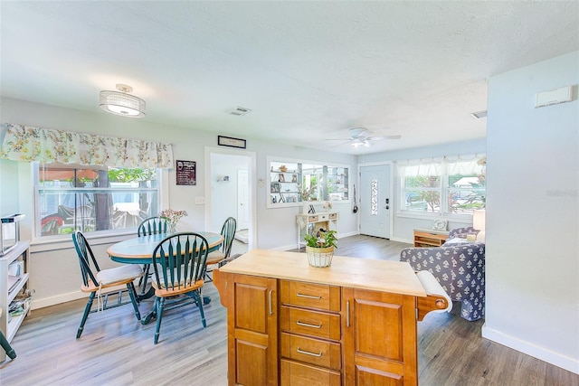 kitchen featuring ceiling fan, a kitchen island, and wood-type flooring