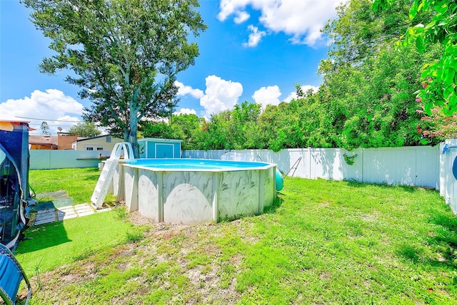 view of yard with a storage unit and a fenced in pool