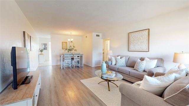 living room featuring an inviting chandelier and light wood-type flooring