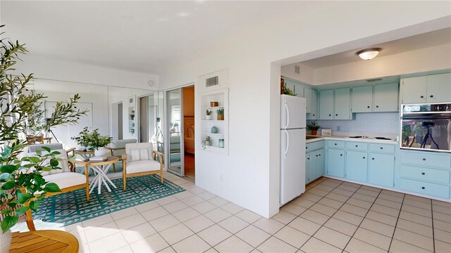 kitchen featuring white appliances, light tile patterned floors, and tasteful backsplash