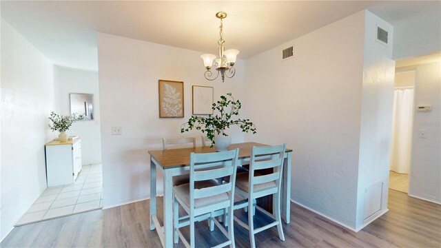 dining room featuring light hardwood / wood-style flooring and a chandelier