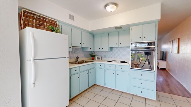 kitchen with backsplash, white appliances, sink, and light tile patterned floors