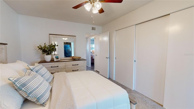 carpeted bedroom featuring ceiling fan and a closet