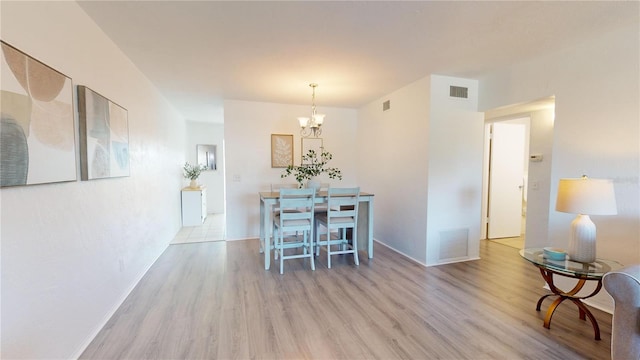 dining area featuring a notable chandelier and light hardwood / wood-style flooring