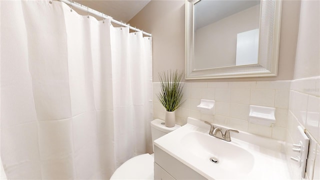 bathroom with vanity, tile walls, and toilet