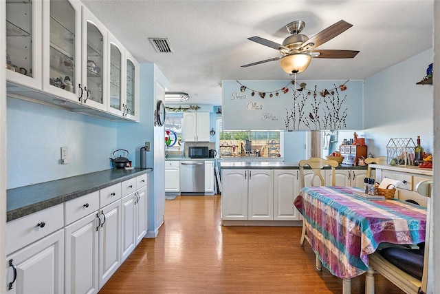 kitchen with white cabinetry, ceiling fan, dishwasher, and light hardwood / wood-style flooring