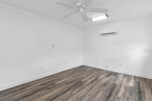 spare room with an AC wall unit, ceiling fan, and dark wood-type flooring