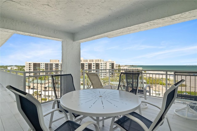 balcony featuring a beach view and a water view