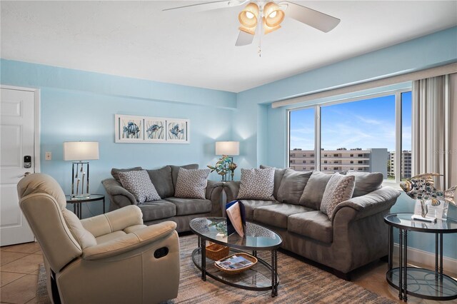 living room with ceiling fan and dark tile patterned flooring