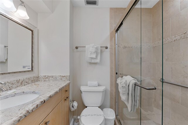 bathroom featuring toilet, vanity, and walk in shower