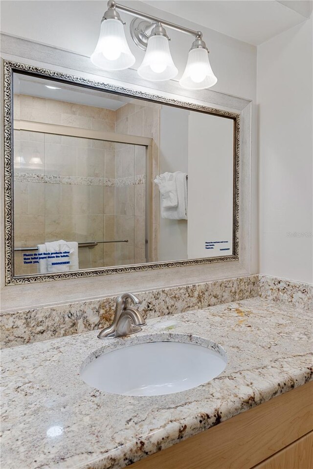 bathroom featuring vanity and a shower with door