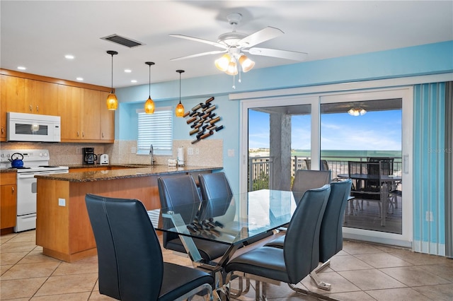 dining room with light tile patterned floors, sink, and ceiling fan